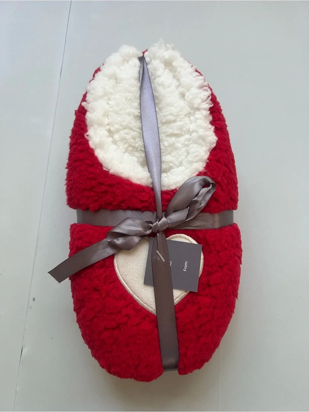 Red & white fuzzy slippers with white heart-shaped patch